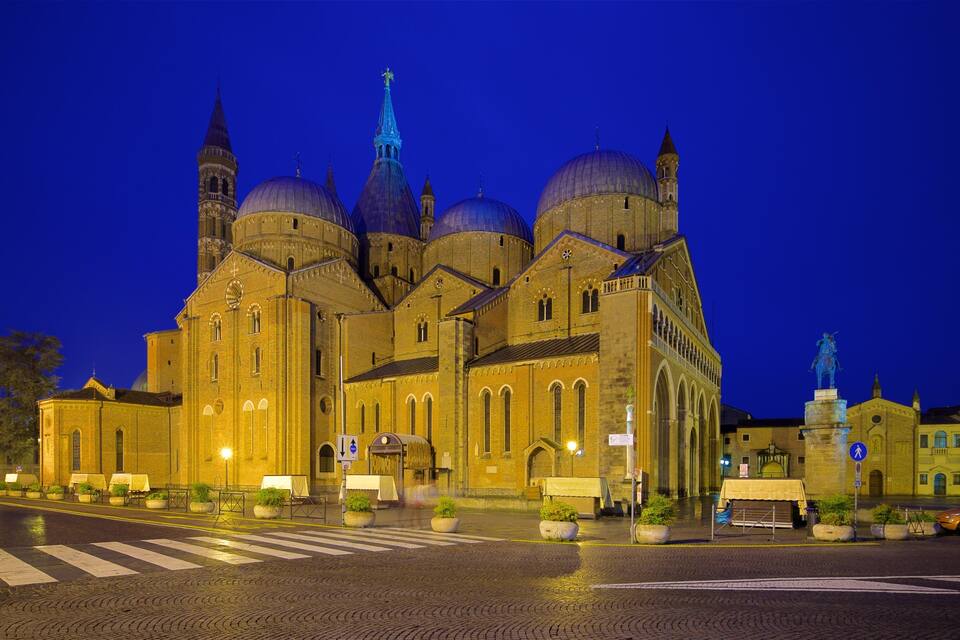 En stor katedral med flere kupler og tårne, belyst om natten.