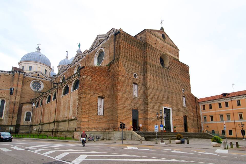 A large brick church with multiple domes and a bell tower.