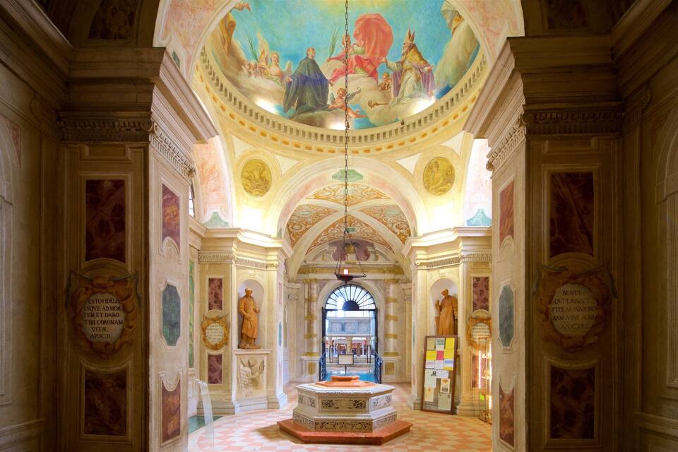 Eine reich verzierte Eingangshalle mit Schachbrettfußboden, Statuen und einer Decke mit Fresken.