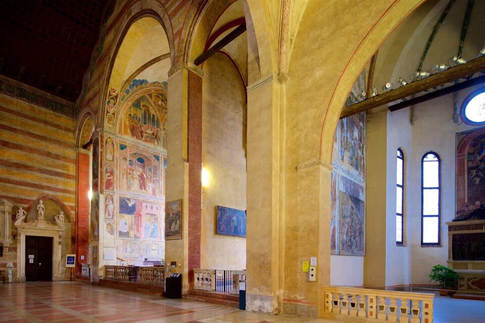 Un vaste hall aux hauts plafonds voûtés, orné de fresques complexes et doté d’une grande fenêtre circulaire.