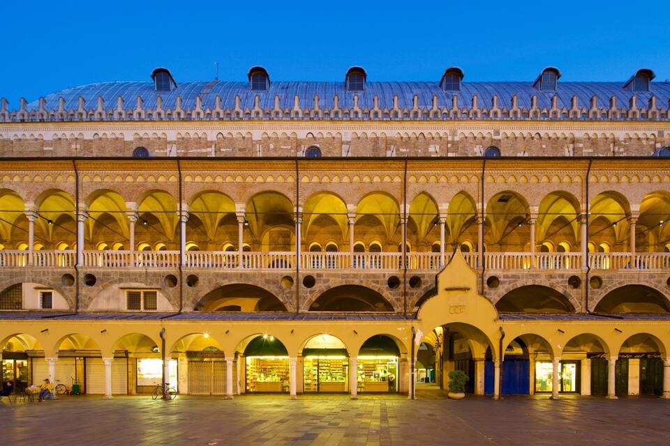 A historic building with multiple arches and a covered upper level.