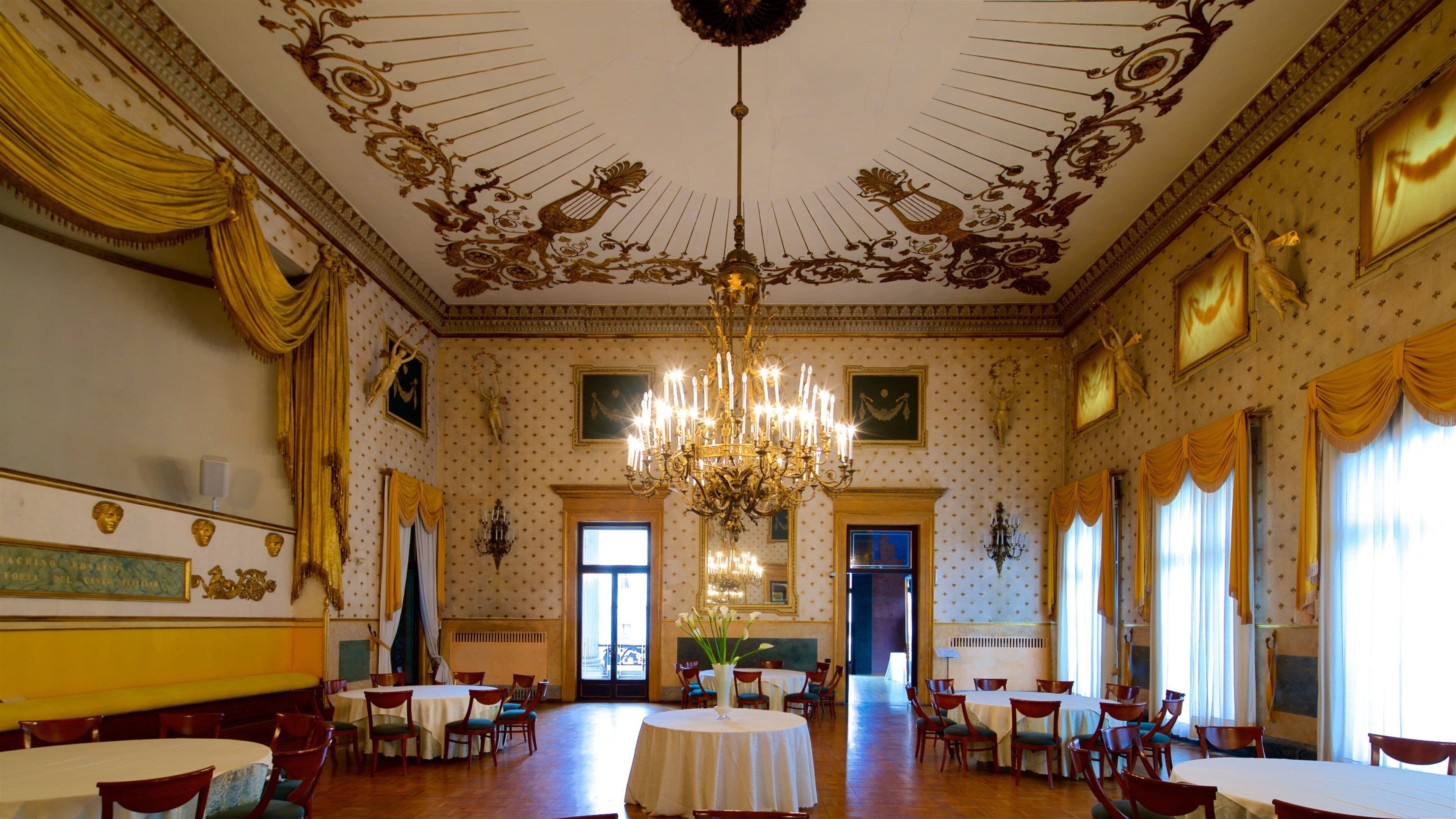 A grand hall with ornate ceiling, chandeliers, and classical decor.