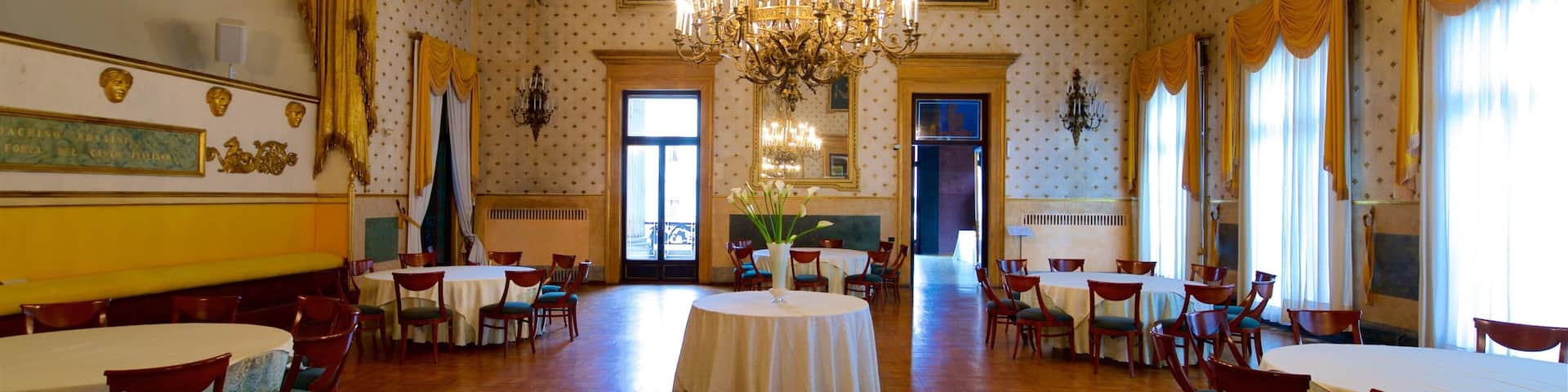 A grand hall with ornate ceiling, chandeliers, and classical decor.