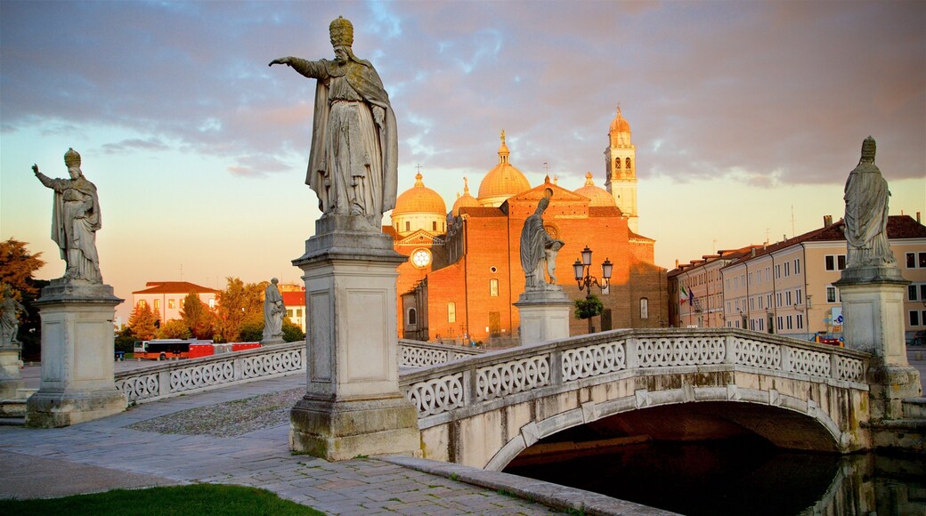 Prato della Valle que incluye una estatua o escultura, un río o arroyo y una puesta de sol