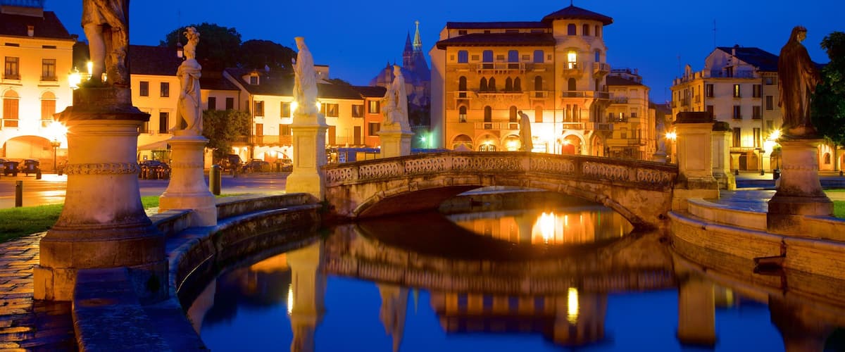 Prato della Valle mostrando una estatua o escultura, escenas nocturnas y un puente