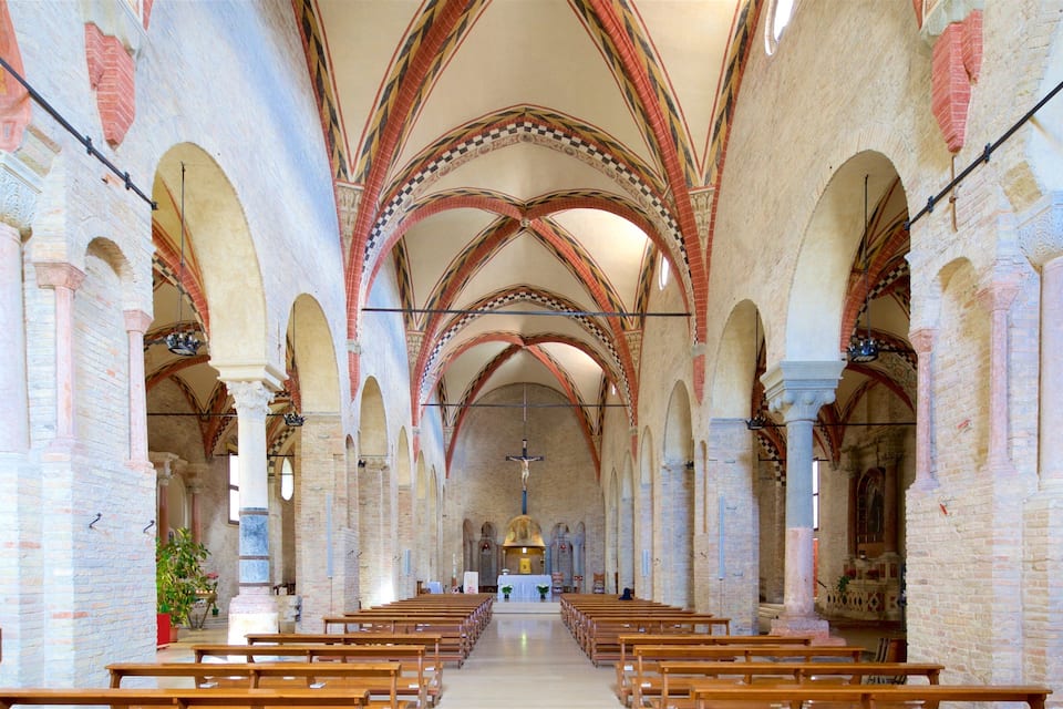 An interior of a church with arched ceilings, wooden pews, and a crucifix at the altar.