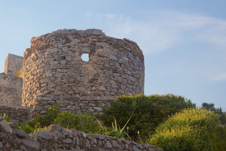 Uma torre de pedra com estrutura circular e uma pequena abertura.