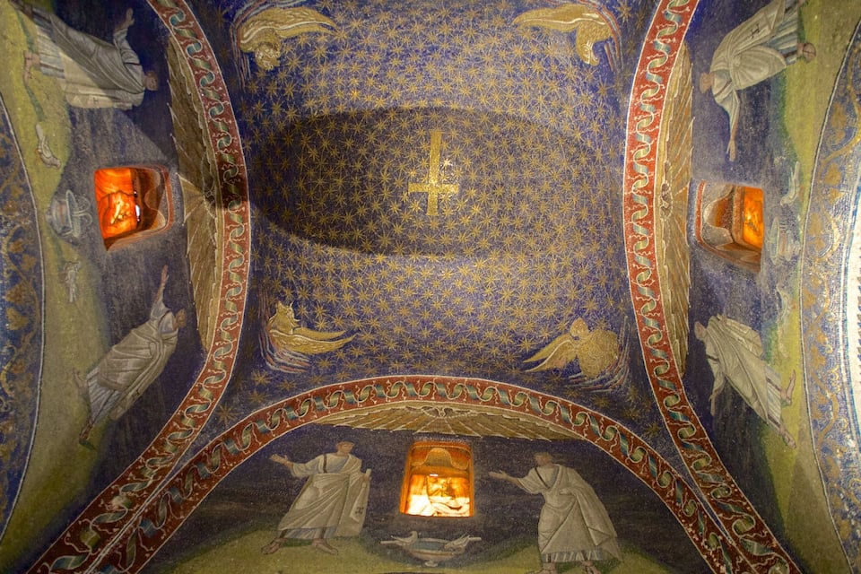 A mosaic with a central cross, surrounded by figures and geometric patterns.