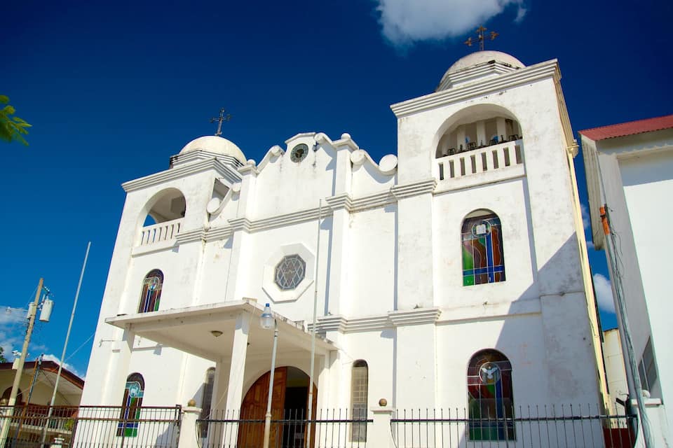 A white church with a bell tower, arched windows, and a dome.