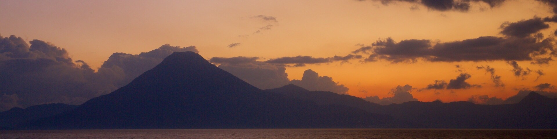 Atitlan Volcano which includes general coastal views, mountains and a sunset