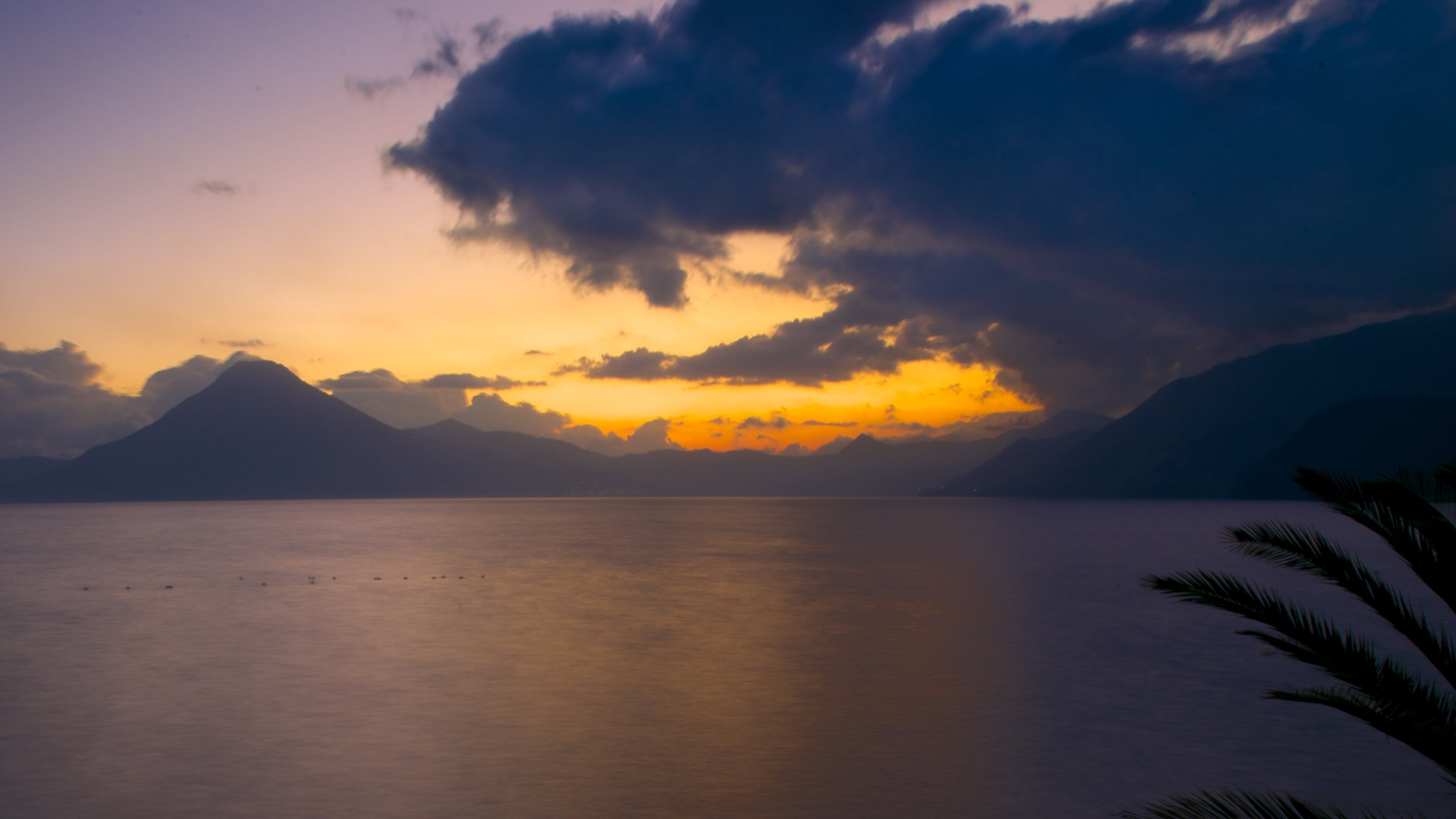 Atitlan Volcano showing general coastal views, a sunset and mountains