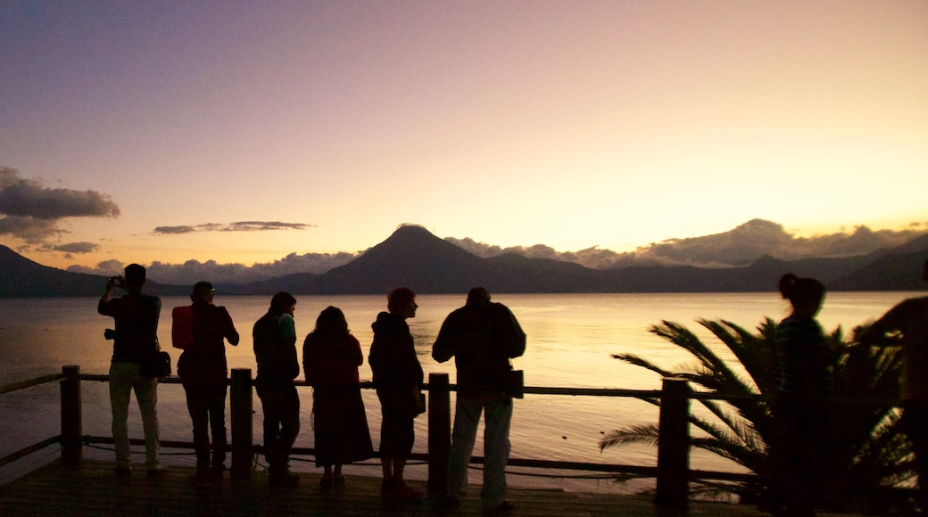 San Pedro Volcano showing general coastal views and a sunset as well as a small group of people