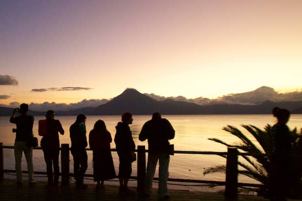 San Pedro Volcano which includes a sunset and general coastal views as well as a small group of people