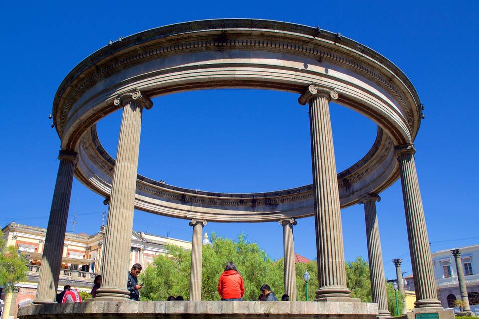 A classical circular structure with columns, surrounded by trees and buildings.