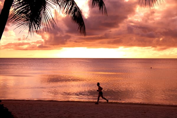 Tumon Beach welches beinhaltet Sonnenuntergang und Strand sowie einzelner Mann