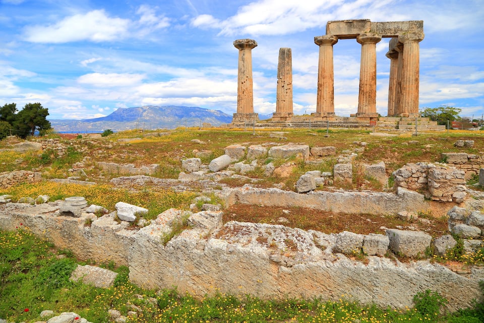 Ancient ruins with columns and scattered stones.