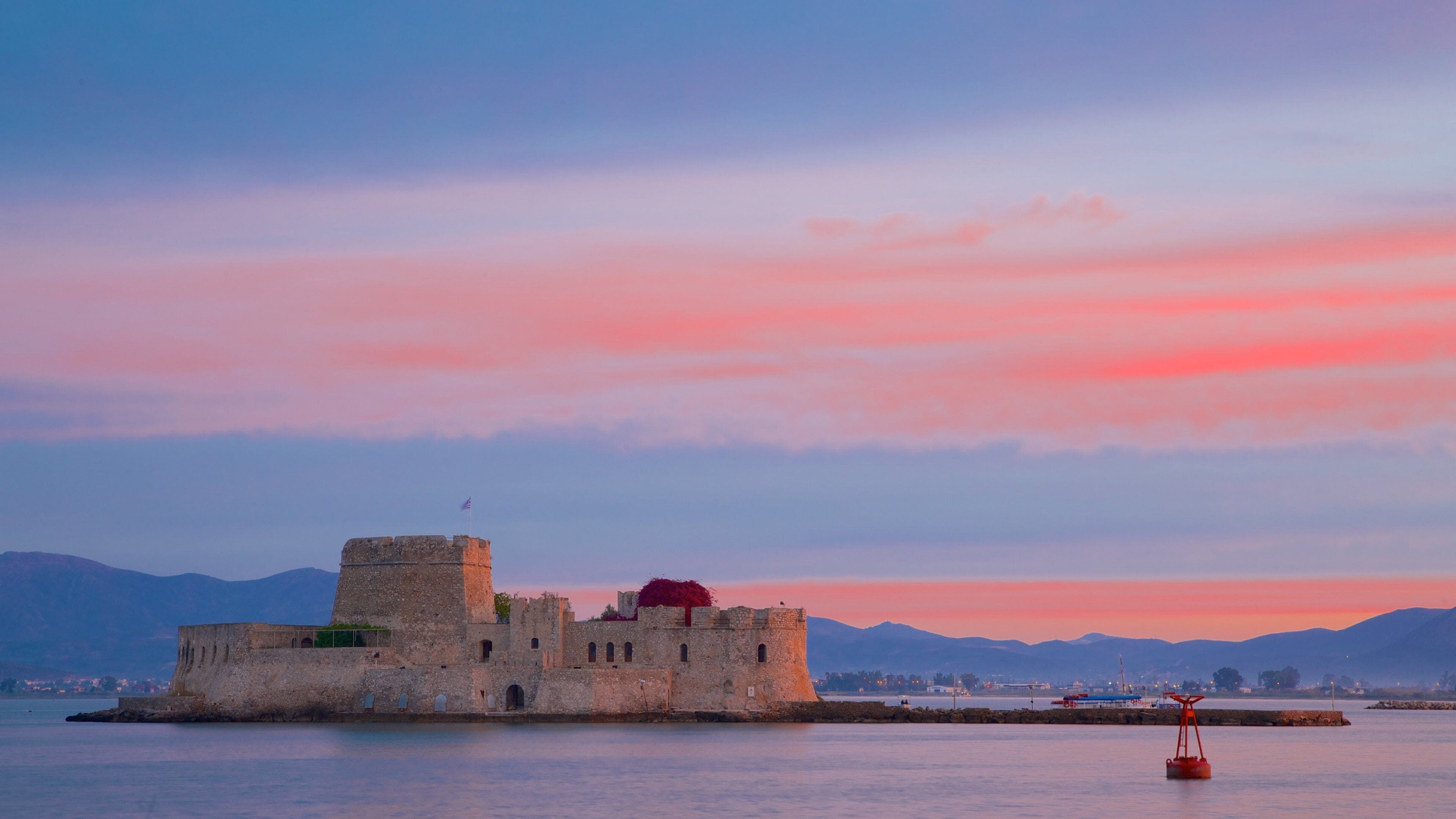 Castle of Bourtzi which includes a sunset, chateau or palace and heritage architecture