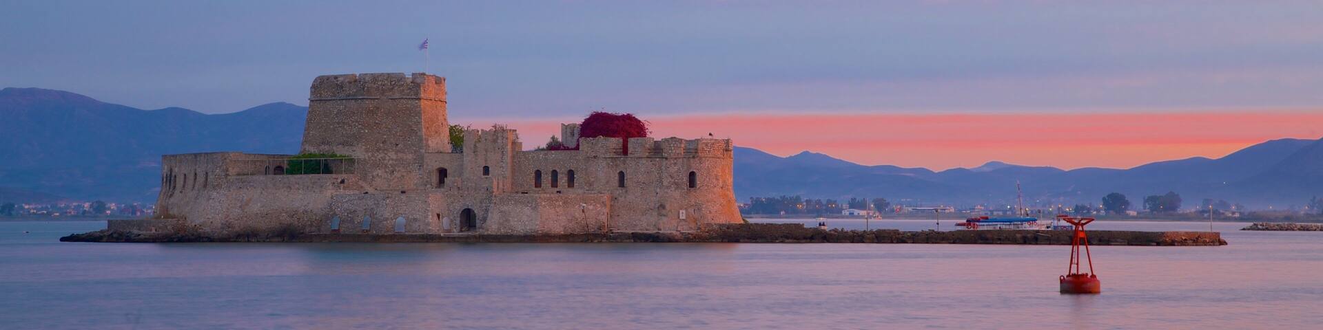 Castle of Bourtzi which includes a sunset, chateau or palace and heritage architecture
