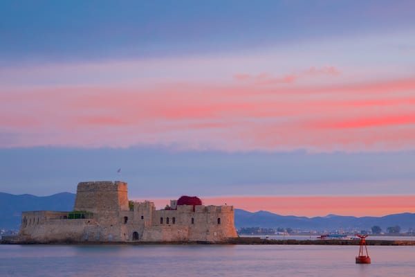 Castle of Bourtzi which includes a sunset, chateau or palace and heritage architecture