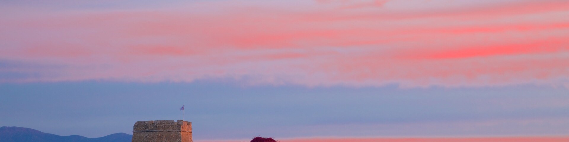 Castle of Bourtzi which includes a sunset, chateau or palace and heritage architecture