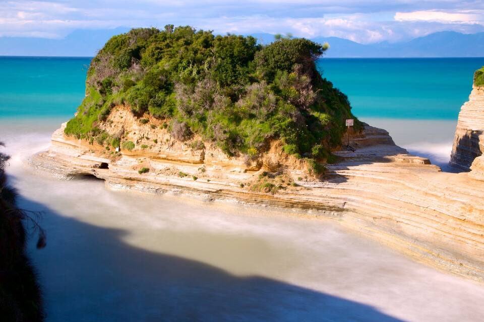 Un paysage côtier caractérisé par des falaises en terrasses et une petite île verdoyante.