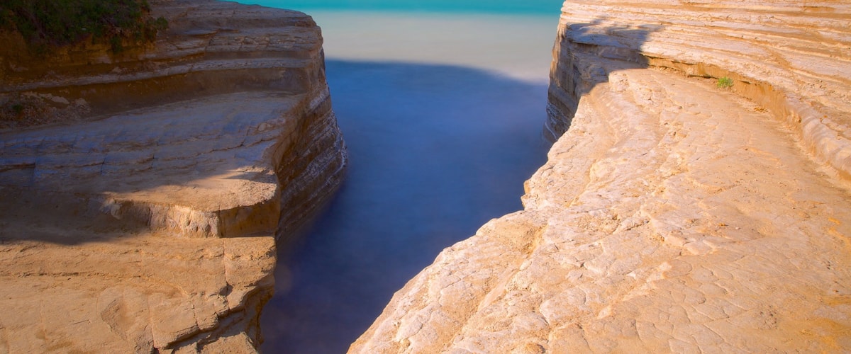A coastal landscape with layered cliffs and a calm sea.