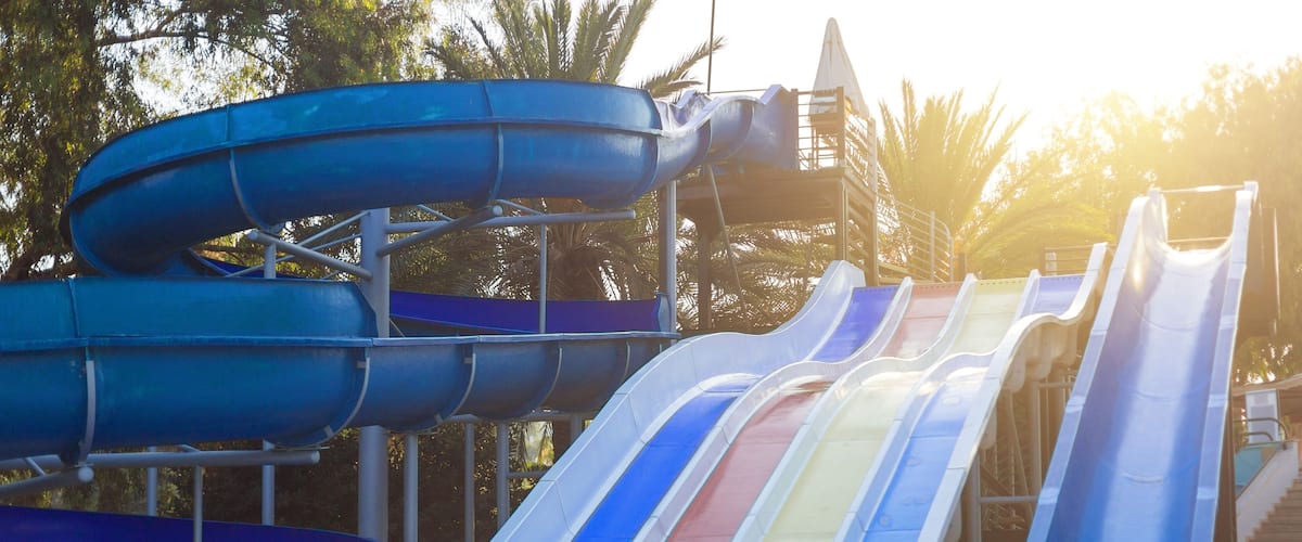 Water slide for summer fun. Three large water slides different colors near the pool