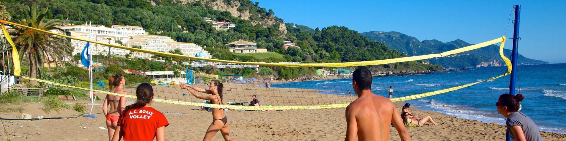 Pelekas Beach featuring a coastal town and a sandy beach as well as a small group of people