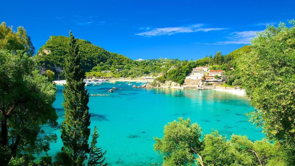 A coastal town with turquoise waters, boats, and lush greenery.