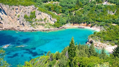Paisagem costeira com águas turquesa cristalinas, falésias rochosas e vegetação verde exuberante.