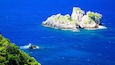 A rocky island surrounded by deep blue sea.