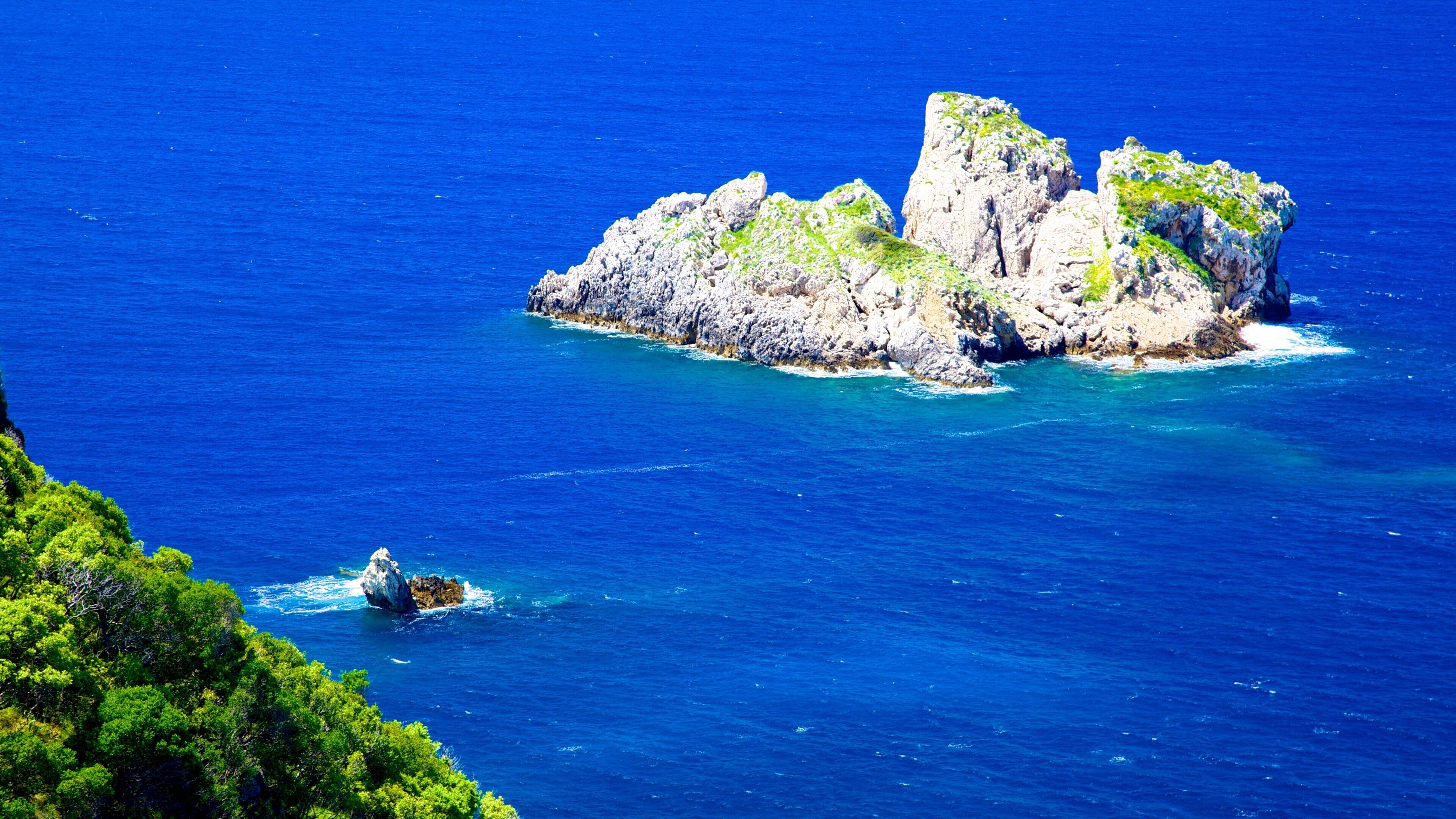 A rocky island surrounded by deep blue sea.