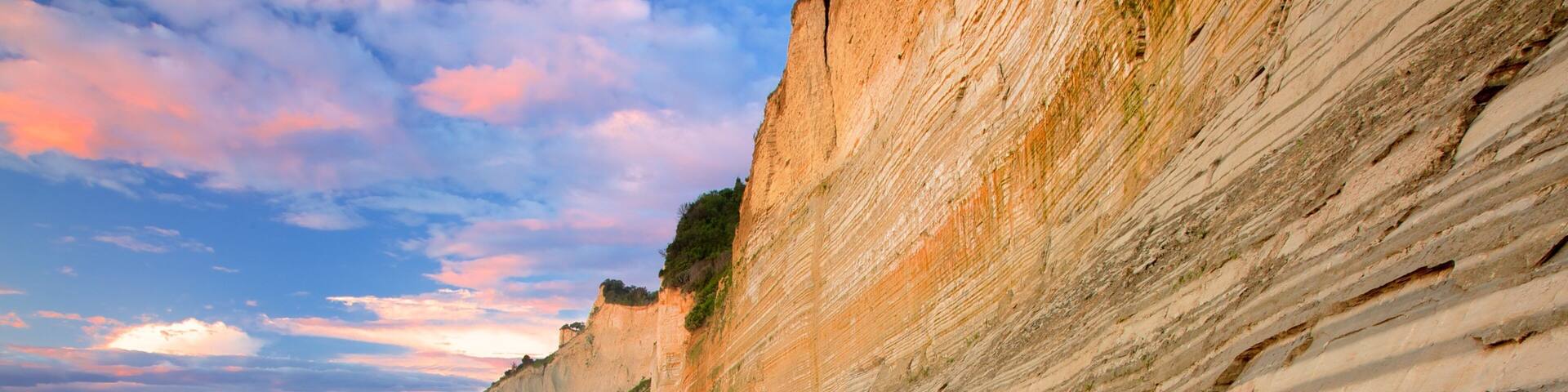 Sunset Beach which includes a sunset and rugged coastline