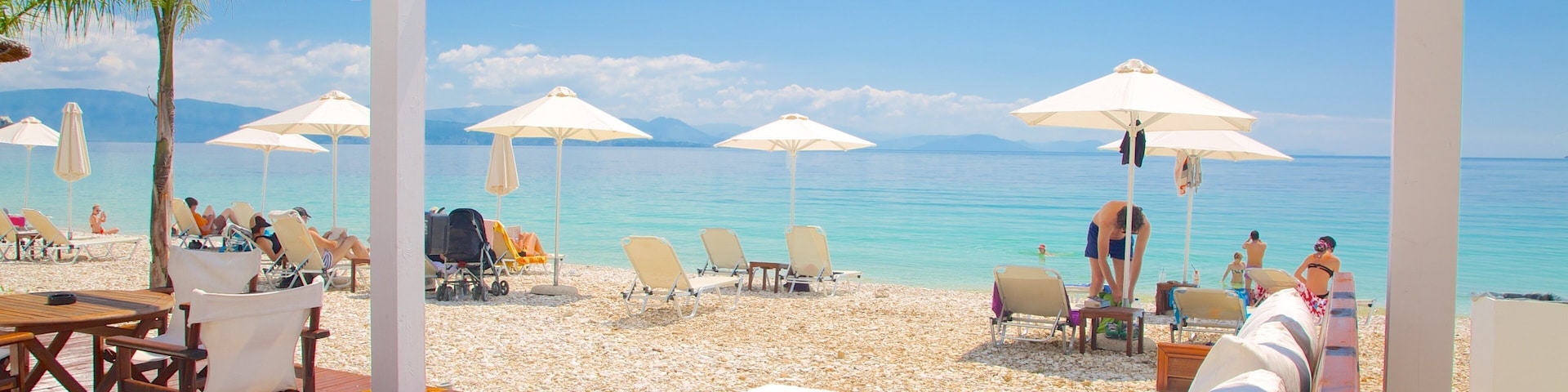Praia de Barbati caracterizando um bar na praia, uma praia de areia e paisagem