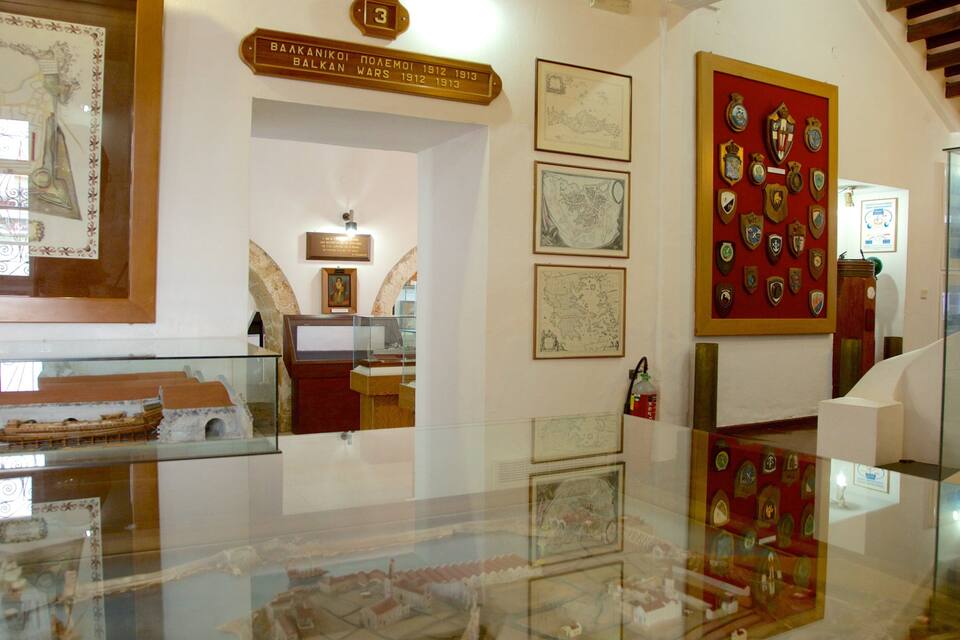 Interior d'un museu amb exposicions històriques, incloent mapes, una maqueta de vaixell i una col·lecció de medalles.