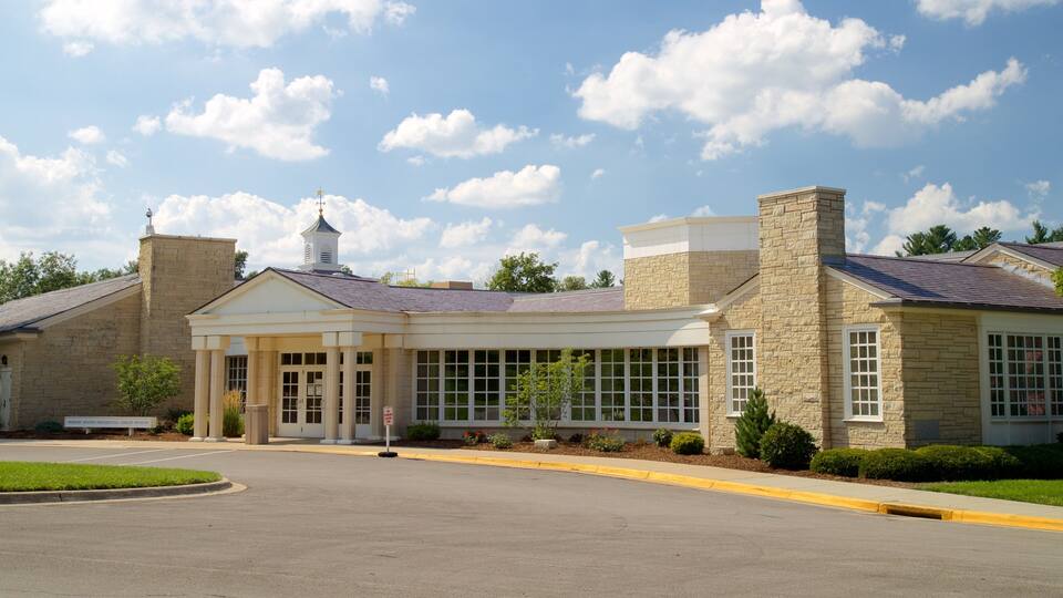 A library building with a covered entrance, stone walls, and a clear sky.