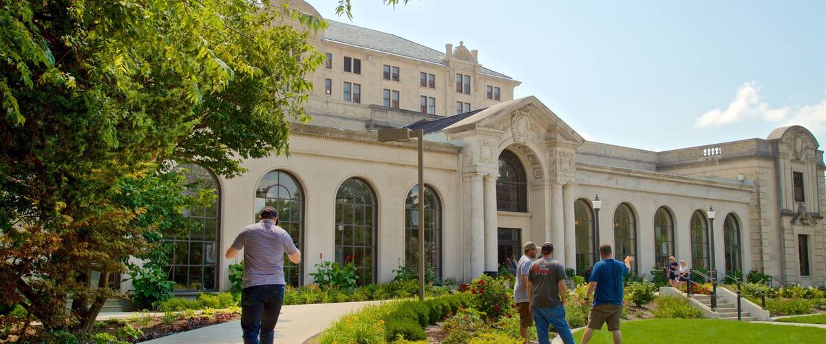 A building with arched windows and a garden with various plants and flowers.