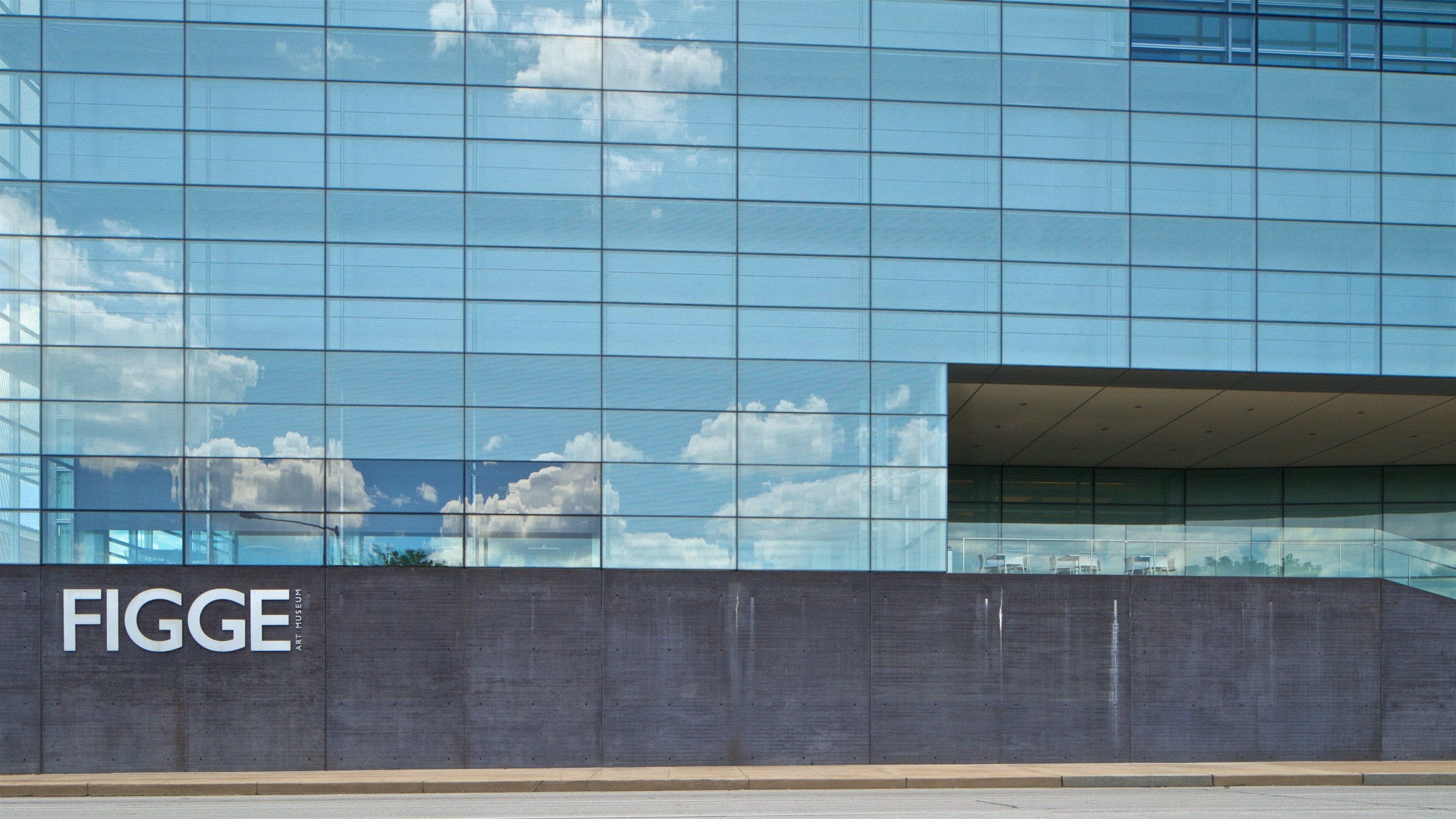 A modern building with reflective glass windows and a concrete facade.