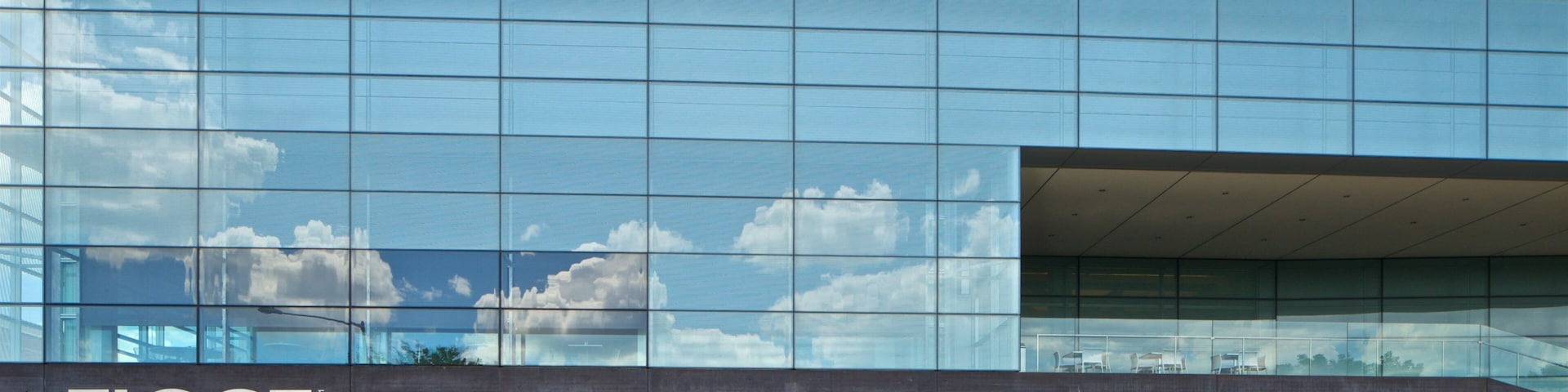 A modern building with reflective glass windows and a concrete facade.