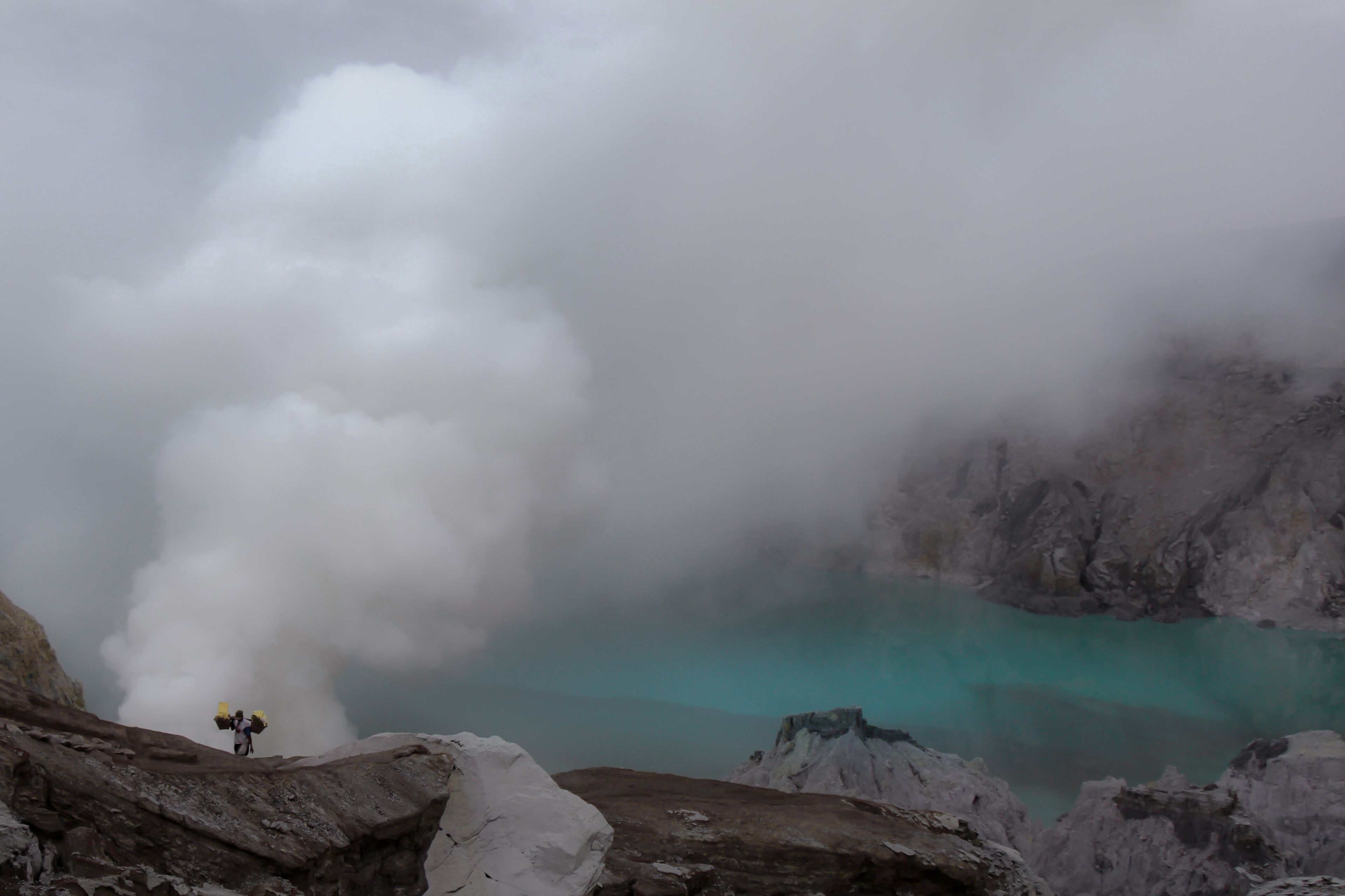 A sulphur miner treks up the steep slopes of Kawah Ijen in Eastern Java