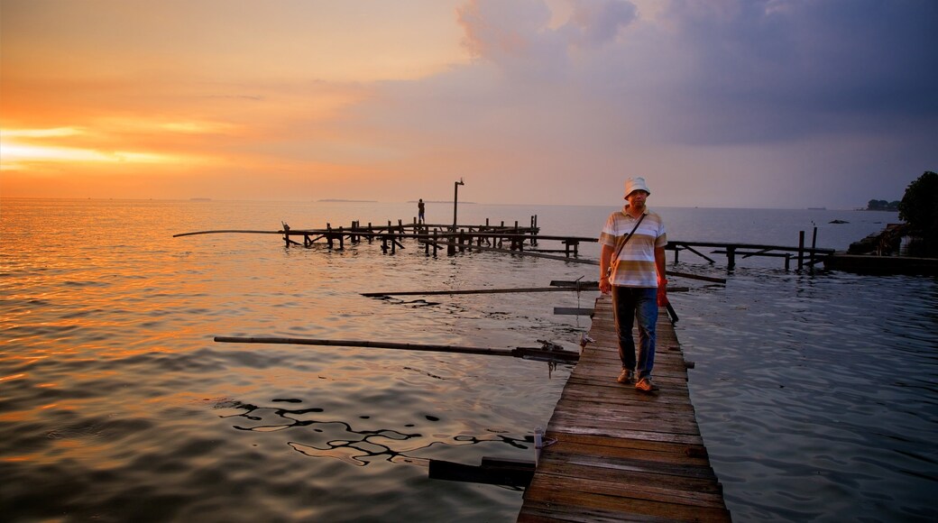 Parc national de Kepulauan Seribu qui includes vues littorales et coucher de soleil aussi bien que homme