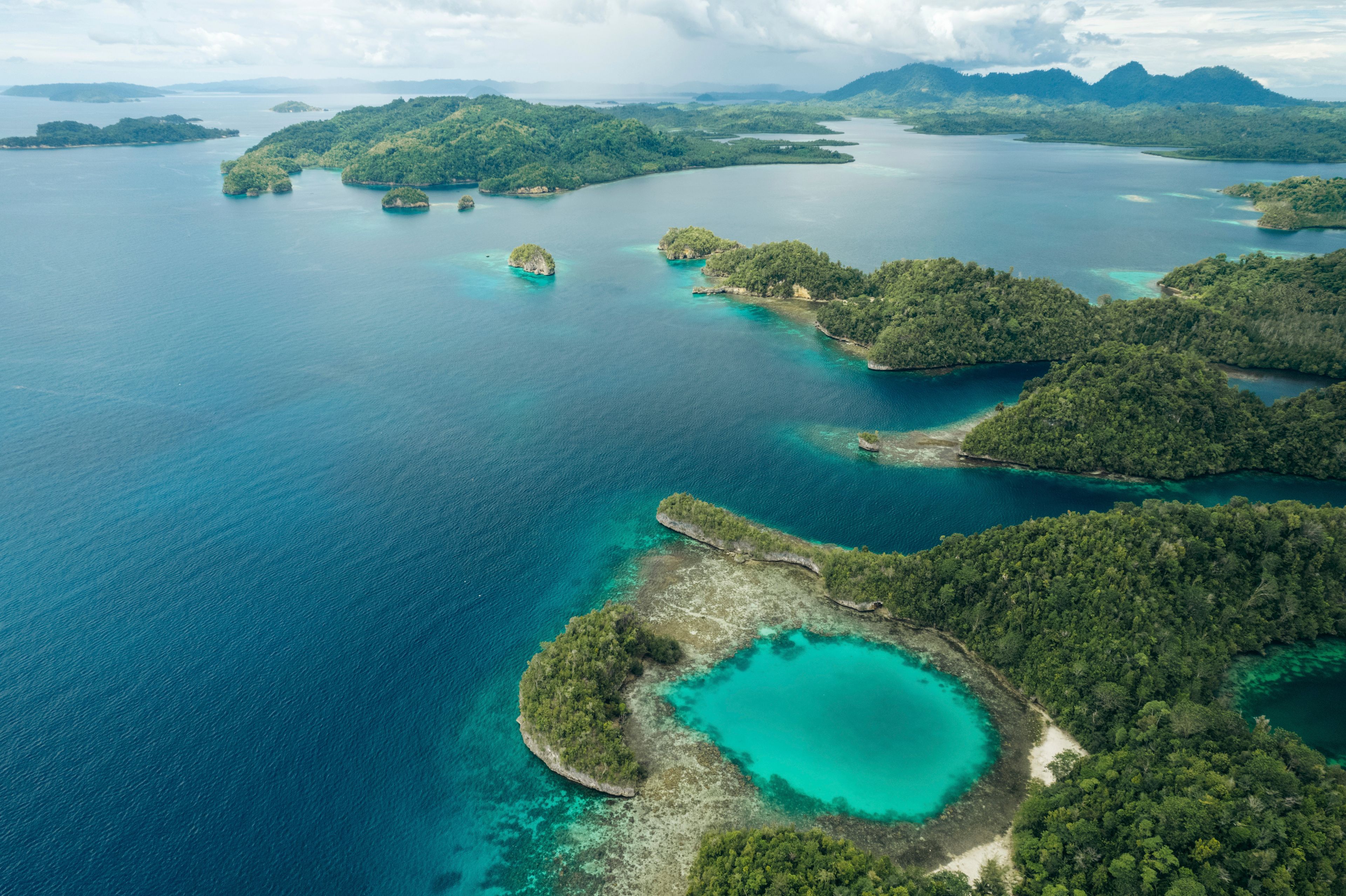 An aerial view of a tropical archipelago with multiple islands surrounded by turquoise waters.