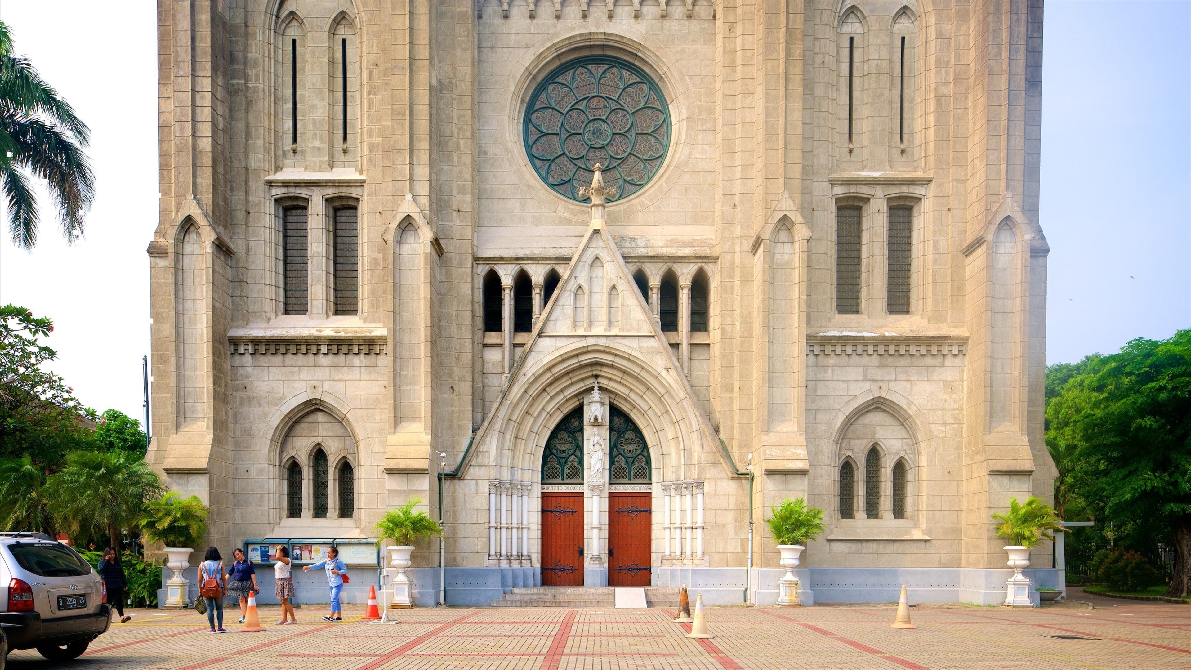 A large cathedral with a prominent rose window and two large wooden doors.