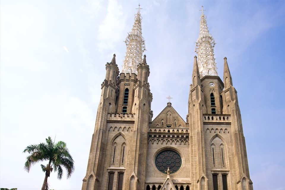 Une grande cathédrale dotée de deux hautes flèches et d’une vaste fenêtre circulaire.