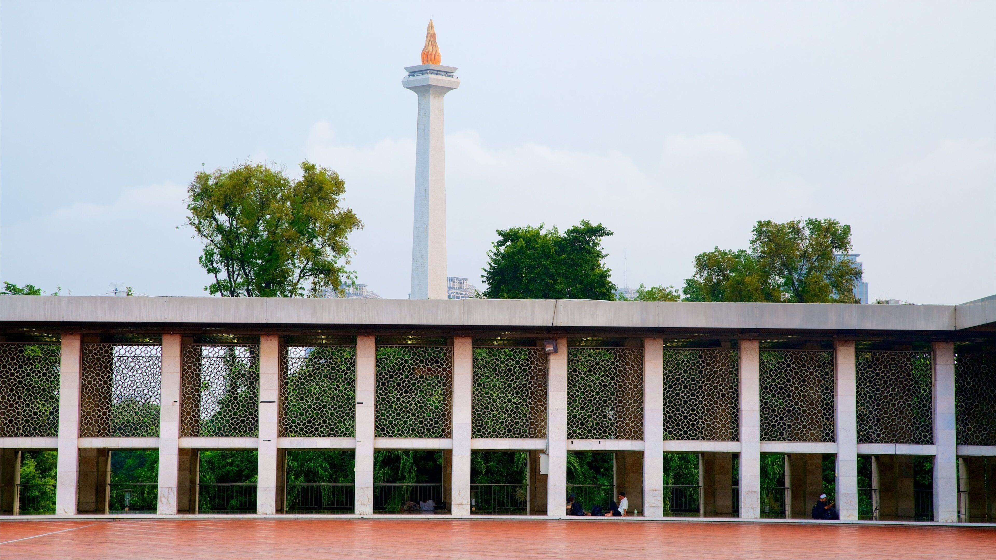 A modern building with a tall tower and a hexagonal patterned facade.