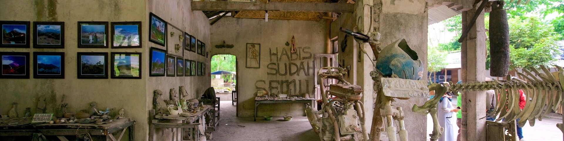 An old, rustic building with a sign reading "HABIS SUDAH SEMULA" and various antique items displayed inside.