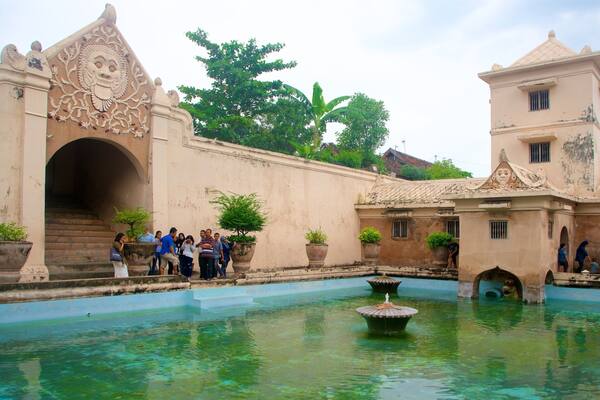 Water Castle which includes heritage architecture and a pool as well as a small group of people