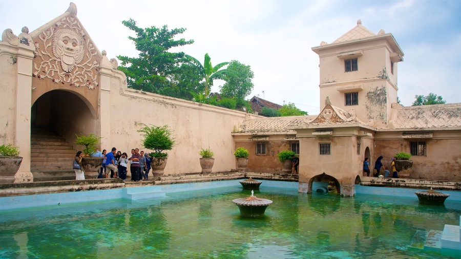 Water Castle showing heritage architecture and a pool as well as a small group of people