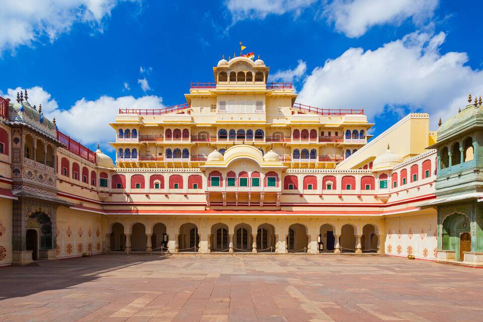 A large, ornate building with multiple arches and balconies, surrounded by a courtyard.