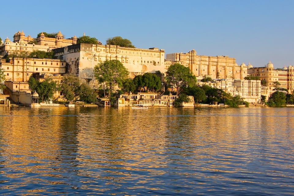 Un ensemble historique comprenant un fort et un palais, situé au bord d’une rivière, et dont les bâtiments se reflètent dans l’eau.